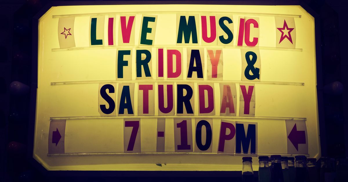 Illuminated vintage marquee promoting live music nights on Friday and Saturday.